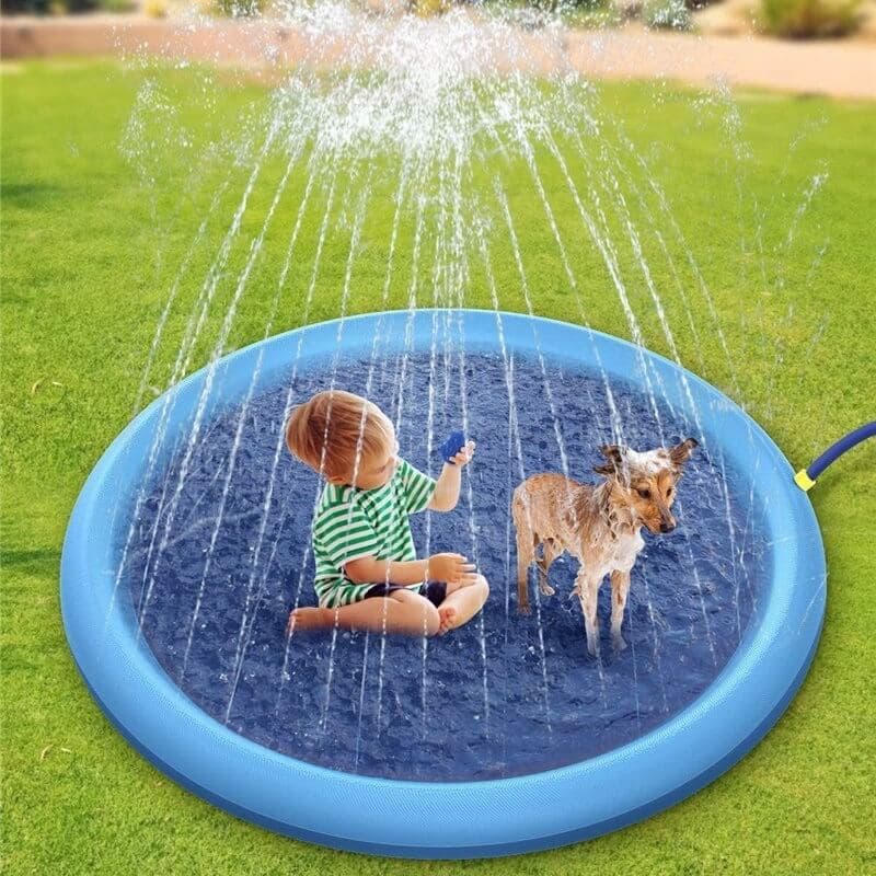 Child and dog playing with a blue inflatable sprinkler pad on grass - Greater Toys Store
